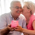 Real Happy senior couple with piggy bank