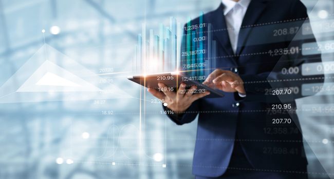 Businessman using tablet analyzing sales data and economic growt