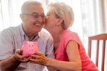 Real Happy senior couple with piggy bank
