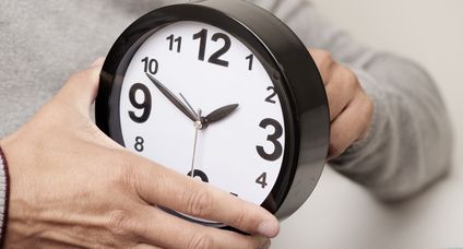 man adjusting the time of a clock